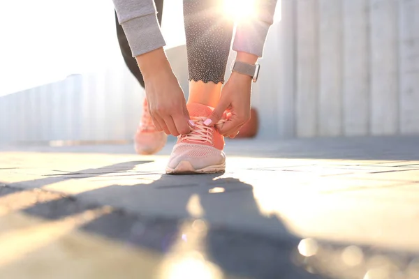 Close-up van onherkenbaar Sportvrouw koppelverkoop schoenen tijdens de avond run buitenshuis — Stockfoto