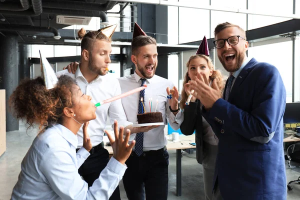 Business team celebrating a birthday of collegue in the modern office