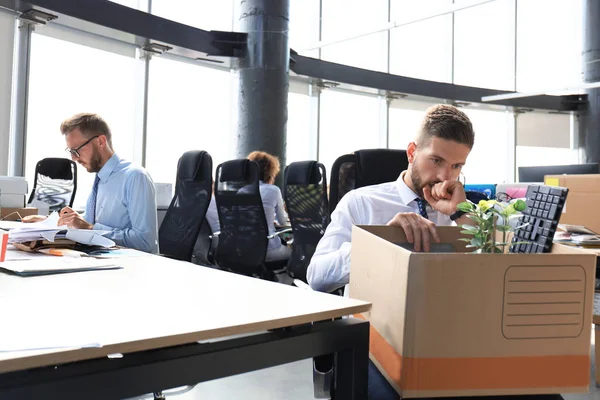 Smutny zwolniony pracownik zabiera ze sobą z biura materiały biurowe. — Zdjęcie stockowe