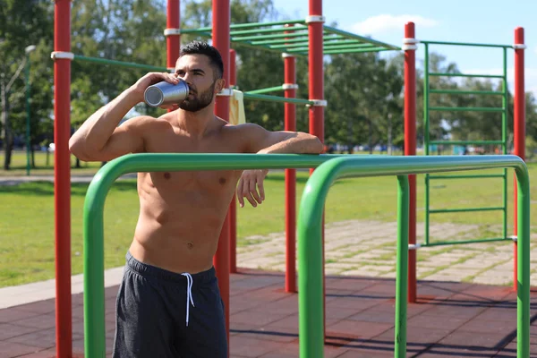 Atleta beber agua y relajarse después de un intenso entrenamiento al aire libre — Foto de Stock