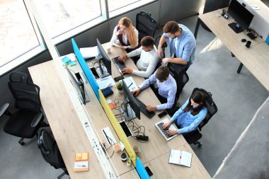 Genç modern iş arkadaşları birlikte ofiste vakit süre çalışan akıllı rahat kıyafet üstten görünüm.