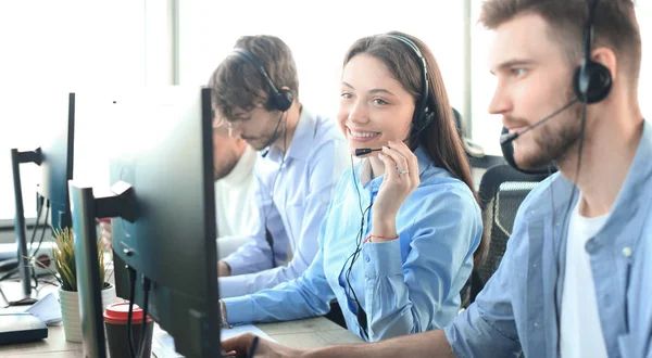 Atractivos jóvenes empresarios y colegas positivos en una oficina de call center. — Foto de Stock