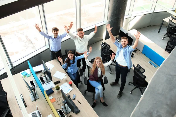 Вид зверху на молодих сучасних колег з розумного повсякденного одягу, які працюють разом, проводячи час в офісі . — стокове фото