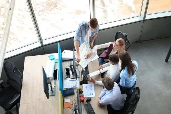 Blick von oben auf junge moderne Kollegen in schicker Freizeitkleidung, die gemeinsam Zeit im Büro verbringen. — Stockfoto