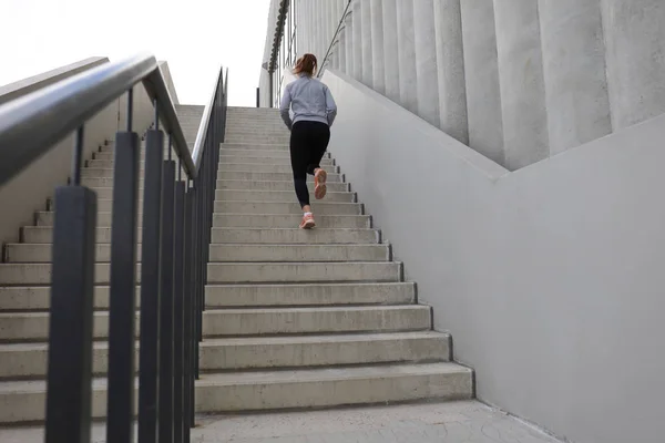 Vista trasera del atleta corredor corriendo por las escaleras. Mujer fitness es trotar al aire libre —  Fotos de Stock