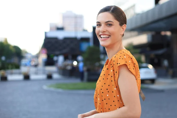 Portrait femme de mode en robe jaune marchant dans la rue de la ville, souriant à la caméra — Photo