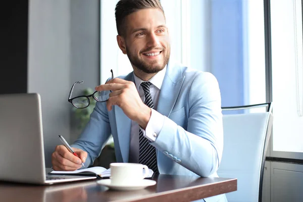 Retrato de hombre de negocios feliz sentado en el escritorio de la oficina, sonriendo — Foto de Stock