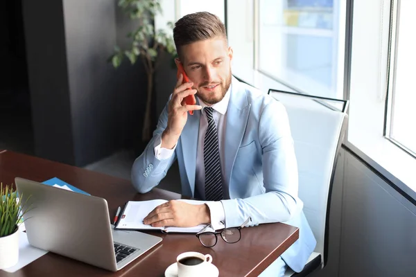 Zakenman met zijn mobiele telefoon op kantoor. — Stockfoto