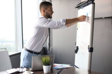 Modern işadamı ofiste flipchart kullanıyor