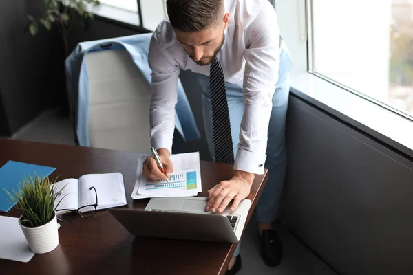 Eleganter moderner Geschäftsmann, der Daten analysiert, während er im Büro arbeitet — Stockfoto