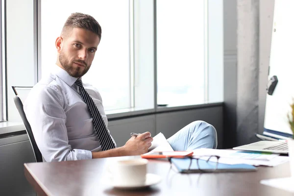 Gerichte moderne zakenman werken en aantekeningen maken in zijn moderne kantoor — Stockfoto