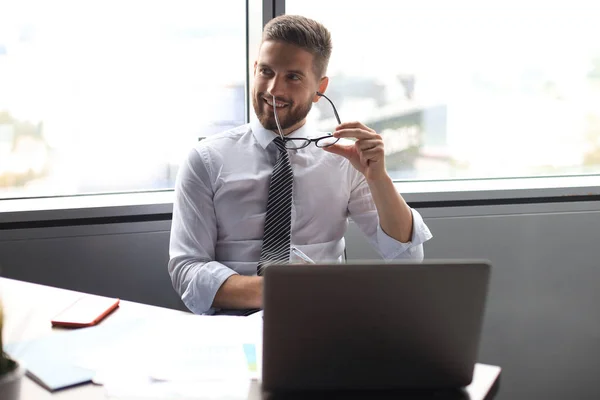 Konzentrierter moderner Geschäftsmann, der in seinem modernen Büro arbeitet und Notizen macht — Stockfoto