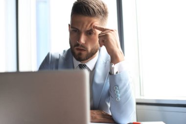 Modern işadamı ofiste otururken bir şey düşünüyor