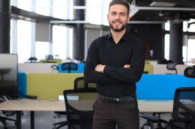 Modern iş adamı ofiste masanın yanında duruyor