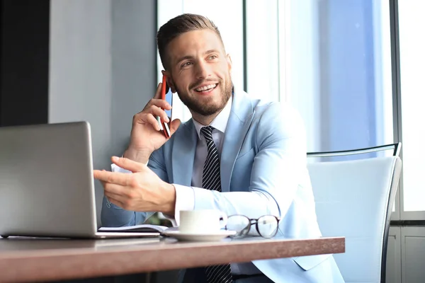 Empresario usando su teléfono móvil en la oficina. — Foto de Stock