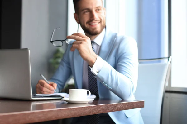 Retrato de hombre de negocios feliz sentado en el escritorio de la oficina, sonriendo — Foto de Stock