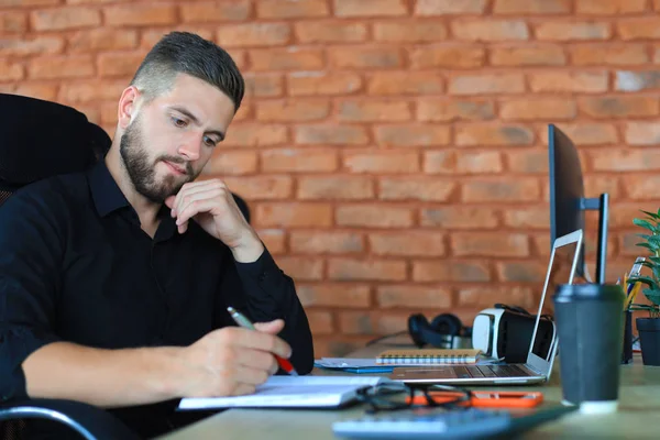 Επικεντρωμένος σύγχρονος επιχειρηματίας που εργάζεται και λαμβάνει σημειώσεις στο σύγχρονο γραφείο του — Φωτογραφία Αρχείου