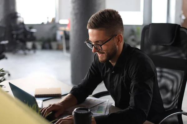 Junger moderner Geschäftsmann analysiert Daten mit Laptop bei der Arbeit im Büro — Stockfoto