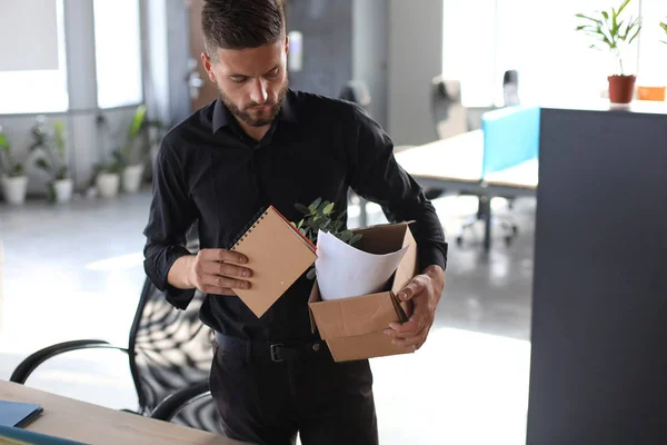 Smutny zwolniony pracownik zabiera ze sobą materiały biurowe z biura. — Zdjęcie stockowe