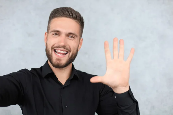 Retrato del hombre sonriente con la mano levantada en saludo. Alto concepto de cinco —  Fotos de Stock