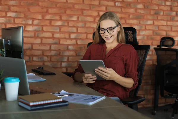 Piękna kobieta biznesu pracuje przy użyciu tabletu cyfrowego siedząc w kreatywnym biurze — Zdjęcie stockowe