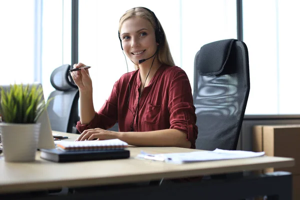 Bella sorridente operatore call center in cuffia sta lavorando presso l'ufficio moderno — Foto Stock