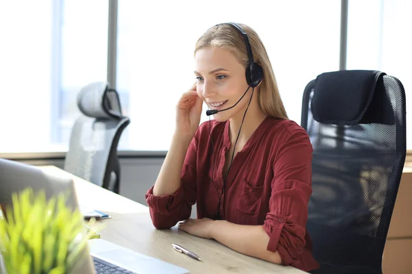 Belle travailleuse du centre d'appels dans les écouteurs travaille au bureau moderne — Photo