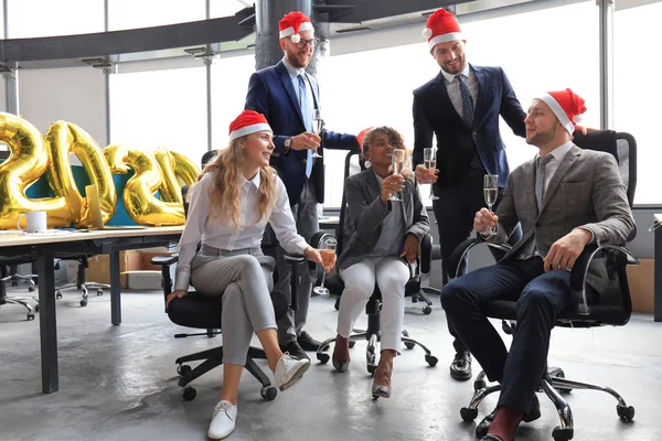 Pessoas de negócios estão comemorando férias no escritório moderno bebendo champanhe e se divertindo em co-working. Feliz Natal e Feliz Ano Novo 2020 . — Fotografia de Stock