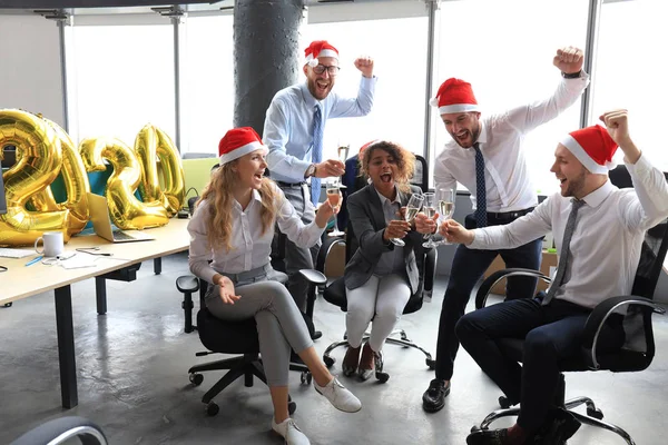 Pessoas de negócios estão comemorando férias no escritório moderno bebendo champanhe e se divertindo em co-working. Feliz Natal e Feliz Ano Novo 2020 . — Fotografia de Stock