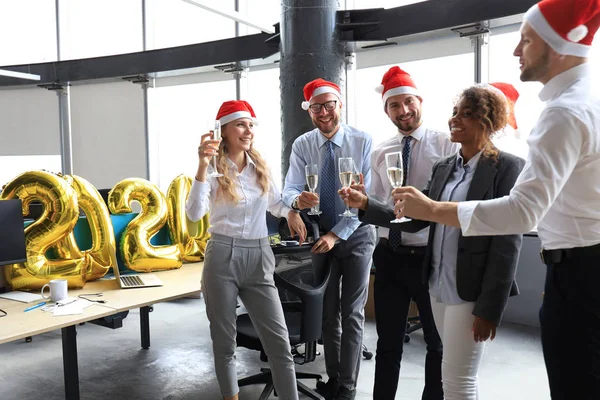 Business people are celebrating holiday in modern office drinking champagne and having fun in coworking. Merry Christmas and Happy New Year 2020. — Stock Photo, Image
