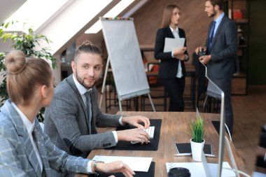 Modern ofis alanı, masaüstü bilgisayarlarında çalışan genç iş adamları.
