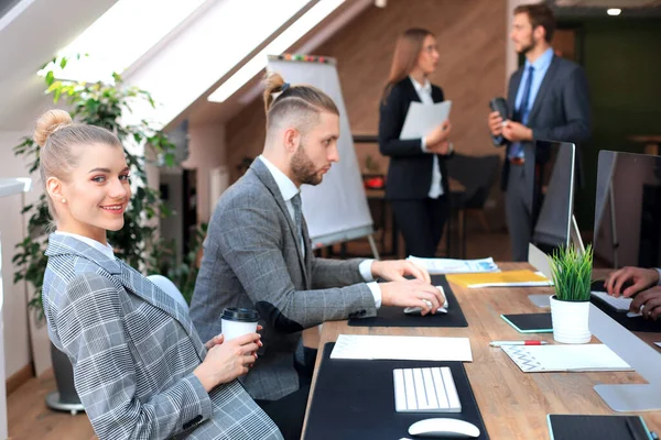 Affärskvinna med sin personal, människor grupp i bakgrunden på moderna ljusa kontor inomhus. — Stockfoto