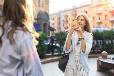 Mutlu kız arkadaşlar şehirde fotoğraf çekiyorlar..