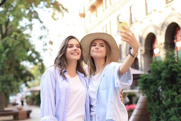 Dois amigos rindo curtindo o fim de semana juntos e fazendo selfie no fundo da cidade . — Fotografia de Stock