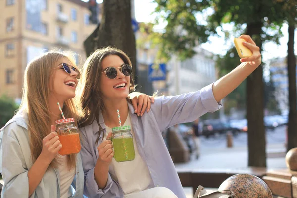 Dois amigos rindo curtindo o fim de semana juntos e fazendo selfie no fundo da cidade . — Fotografia de Stock