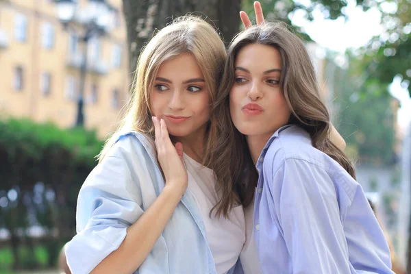 Deux jeunes femmes hipster souriantes en vêtements d'été posant dans la rue.Femme montrant des émotions faciales positives . — Photo