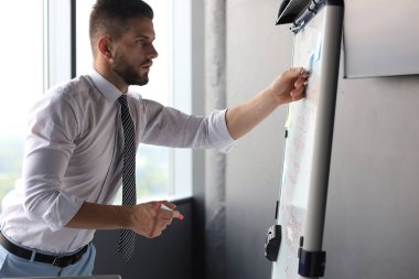 Modern işadamı ofiste flipchart kullanıyor