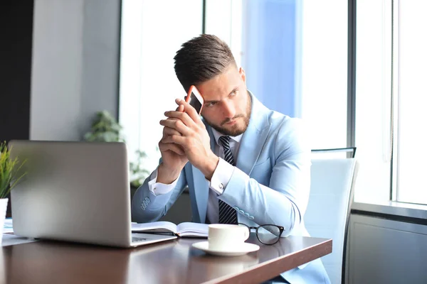 Hombre de negocios moderno pensando en algo mientras está sentado en la oficina — Foto de Stock