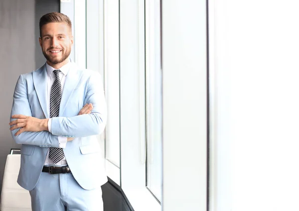 Portret van een gelukkige zakenman met gekruiste armen in functie — Stockfoto