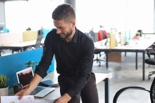 Young man is working with papers while sitting in the office — Stock Photo, Image