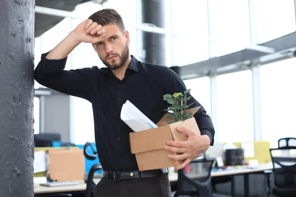 Smutny zwolniony pracownik zabiera ze sobą materiały biurowe z biura. — Zdjęcie stockowe