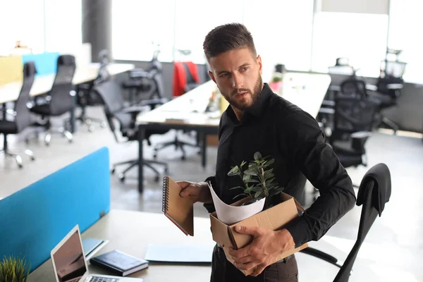 Sad dismissed worker is taking his office supplies with him from office — Stock Photo, Image