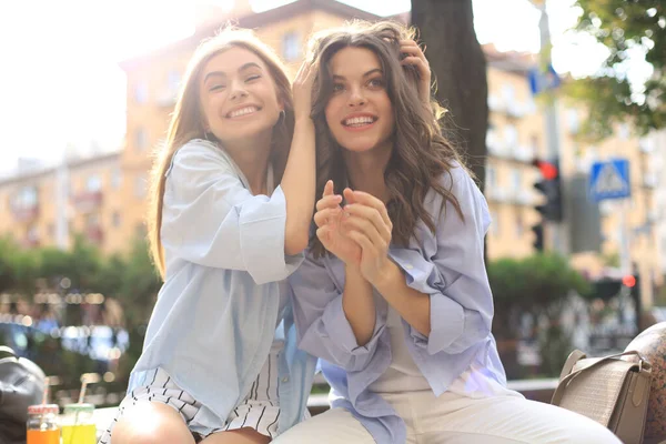 Deux jeunes femmes hipster souriantes en vêtements d'été posant dans la rue.Femme montrant des émotions faciales positives . — Photo