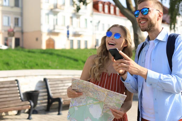 Preciosa pareja de vacaciones están mirando el mapa en busca de dirección — Foto de Stock