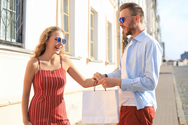 Joven pareja feliz con bolsas de compras en la ciudad — Foto de Stock