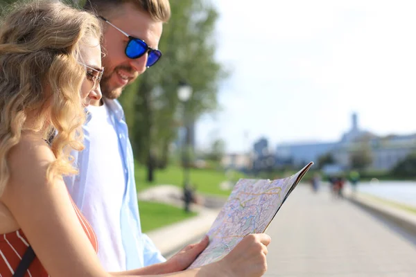 Preciosa pareja de vacaciones están mirando el mapa en busca de dirección —  Fotos de Stock