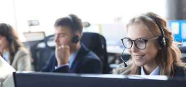 Kulaklıklı ve gülümseyen kadın müşteri destek operatörü.