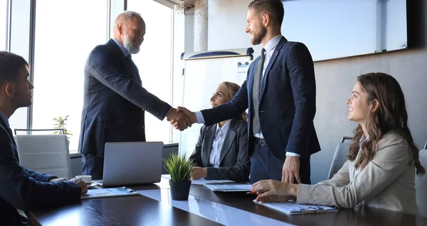 Empresários apertando as mãos, terminando uma reunião. — Fotografia de Stock