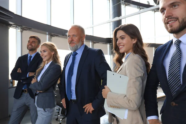 Happy sorrindo equipe de negócios de pé em uma fileira no escritório . — Fotografia de Stock