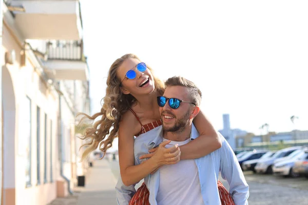 Hermosa pareja joven enamorada caminando al aire libre en la calle de la ciudad, abrazándose — Foto de Stock